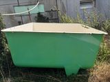 a green bathtub sitting in the middle of a yard