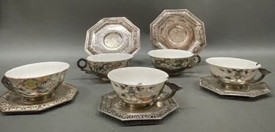 six pieces of silver and white tea cups and saucers on a table