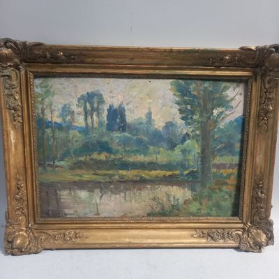 une peinture à l'huile d'un paysage avec des arbres dans un cadre doré