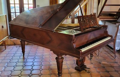 un piano à queue dans une pièce au sol carrelé
