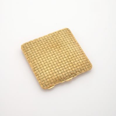 un étui à cigarettes plaqué or posé sur une surface blanche