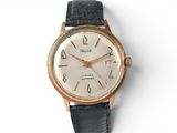 a gold and black watch with roman numerals on the face