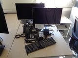 un bureau sur lequel sont posés deux écrans d'ordinateur et un clavier