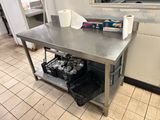 une table en acier inoxydable sur laquelle sont posés deux rouleaux de papier toilette