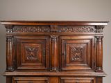 a large wooden cabinet with carvings on the top