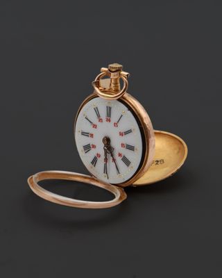 une image d'une montre de poche en or avec des chiffres romains sur le cadran