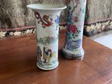 two vases sitting on a table with flowers in them