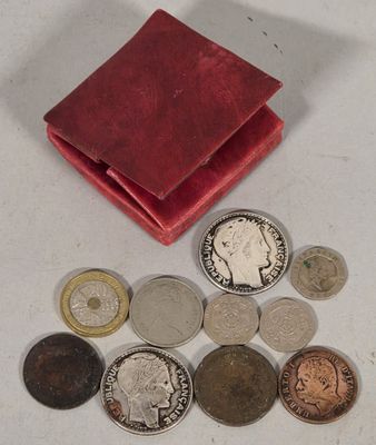 a small red wallet with coins on a white table