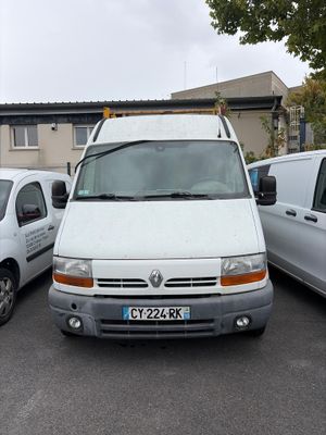 une camionnette blanche garée dans un parking à côté d'autres voitures
