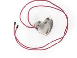 pendentif en argent en forme de cœur avec un cordon rouge sur fond blanc