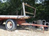 a truck that is sitting in the grass with pipes in the back