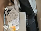 a cardboard box filled with items that include a laptop, keyboard, mouse, and other items
