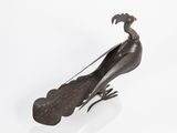 bronze sculpture of a peacock sitting on top of a white surface