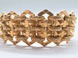une image d'un bracelet en or sur fond blanc