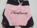 un gros plan sur une culotte rose ornée de dentelle noire