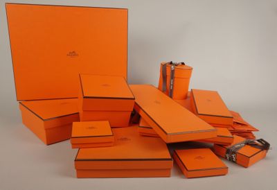 Des boîtes orange sont empilées les unes sur les autres sur une surface blanche
