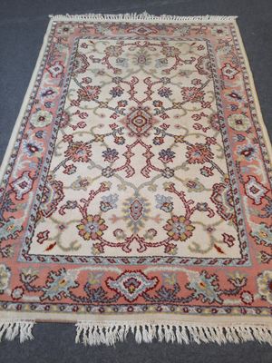 an oriental rug with fringes on the floor