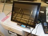 un téléviseur et une télécommande posés sur un bureau