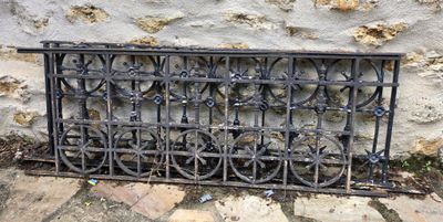 une grille en fer noir ornée de fleurs