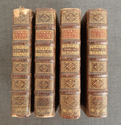 trois vieux livres posés sur une table l'un à côté de l'autre