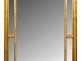 un grand miroir dans un cadre doré, orné d'un motif décoratif