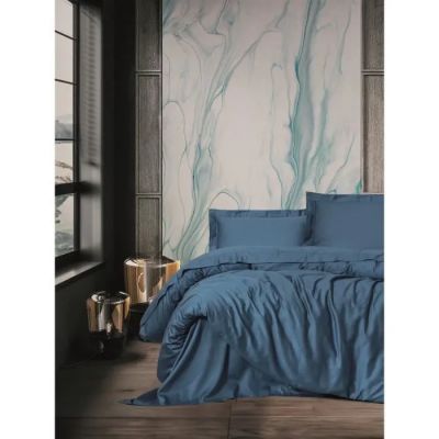 un lit avec une couette bleue et des oreillers dans une chambre