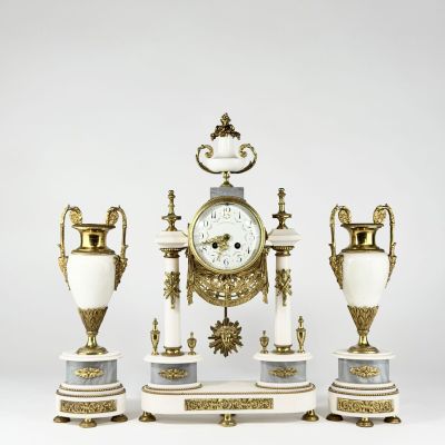 three vases and a clock sitting on a table