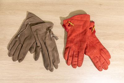 two pairs of gloves sitting on top of a wooden floor