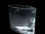 un vase en verre transparent posé sur une surface noire