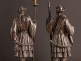 pair of antique bronze figurines of a man and woman holding a candelabra