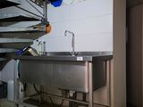 a stainless steel sink in a kitchen next to a staircase
