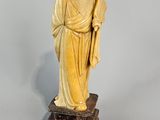 statue d'un homme à la longue barbe, vêtu d'une robe et tenant un bâton