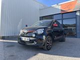 une photo d'une petite voiture noire garée devant un immeuble