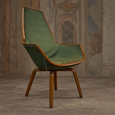 une chaise verte aux pieds en bois dans une pièce