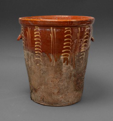 a brown vase that has a design on it