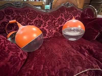 une paire de lampes orange posées sur un canapé rouge dans un salon