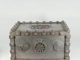 une boîte ancienne en métal argenté, ornée d'un motif décoratif sur le devant