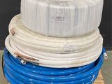 une pile de tuyaux bleus et blancs posée sur une palette