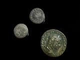 three silver coins sitting next to each other on top of a black surface