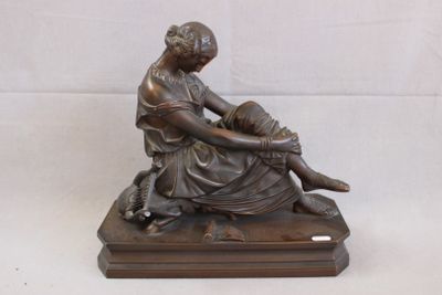 statue en bronze représentant une femme assise sur un socle en bois, accompagnée d'un chien