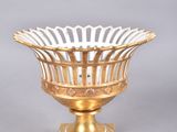 an image of a gold plated bowl on a wooden stand