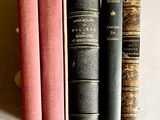 plusieurs vieux livres sont alignés sur une étagère