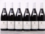 six bouteilles de vin sont alignées sur une table
