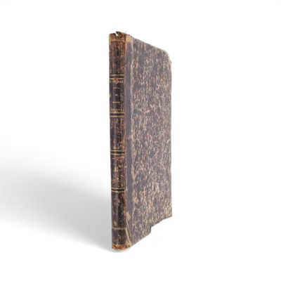un gros plan d'un vieux livre posé sur une surface blanche