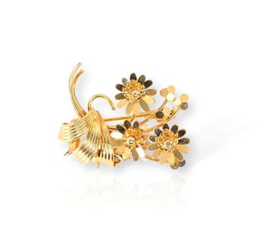 un gros plan d'une broche en or ornée de fleurs