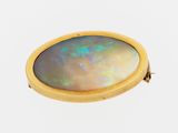 a close up of a yellow gold ring with a black opal in the center