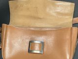 an image of a brown purse with a metal buckle on it