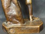 bronze statue of a woman holding a book on a black background