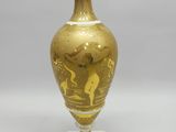 un vase doré posé sur une table blanche