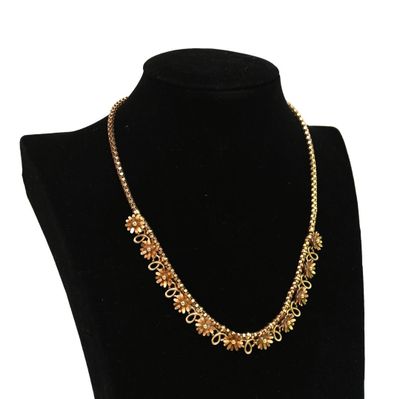 un collier avec une chaîne en or sur un mannequin noir